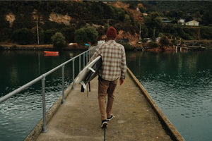 man walking with a surfboard at a dock