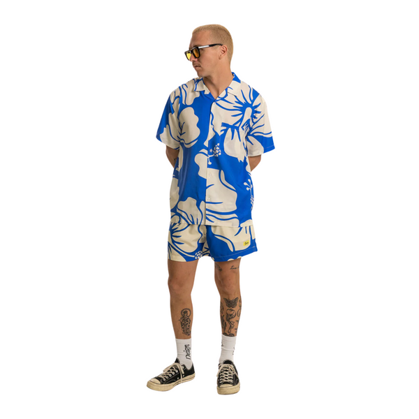 Person wearing the Duvin Paradise Swim Short in Blue at the beach or pool in a sunny, laid-back setting