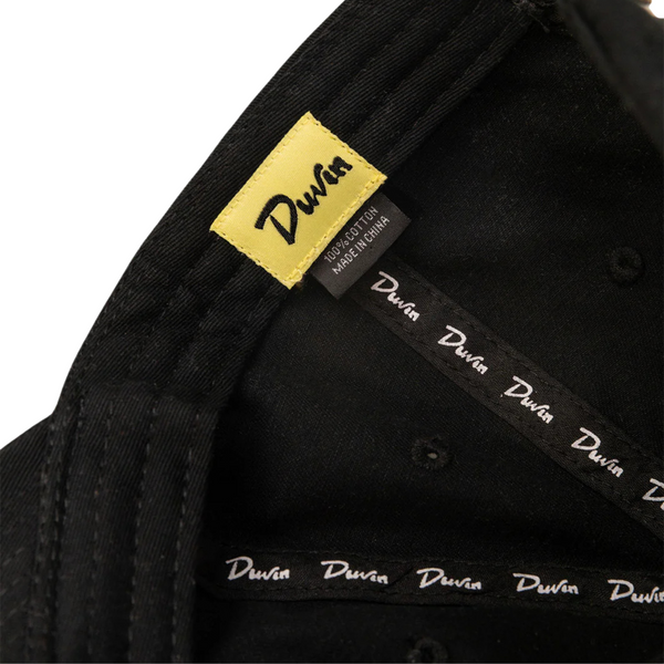 Close-up of “Retired” embroidery and brushed cotton texture on the Duvin Retired Hat in Black