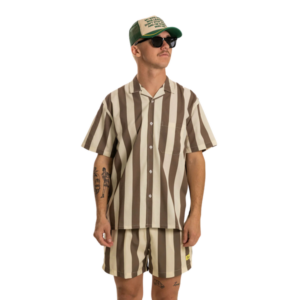 Person wearing the Duvin Travel Swim Short in Brown in a beach or resort setting, styled for movement and comfort