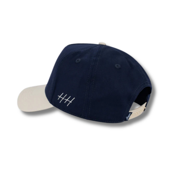 Back view of Huega House Circuit Hat in Natural and Navy with adjustable snapback closure and contrast panel design
