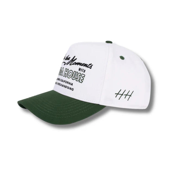 Side view of Huega House Moments Hat in Pine Green/White showing two-tone construction, mid-profile fit, and breathable paneling