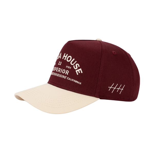 Side view of Huega House Trademark Hat in Natural/Maroon showing curved maroon brim, mid-profile fit, and smooth natural-tone crown
