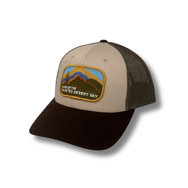 Front view of Local Stated Painted Desert Hat in Tan, Brown, and Green featuring a desert landscape patch on a structured crown with a curved brim