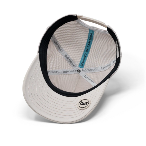 Flat lay of Melin Odysea Mac Retro Hydro in Moon showcasing structured fit, technical materials, and retro-style branding