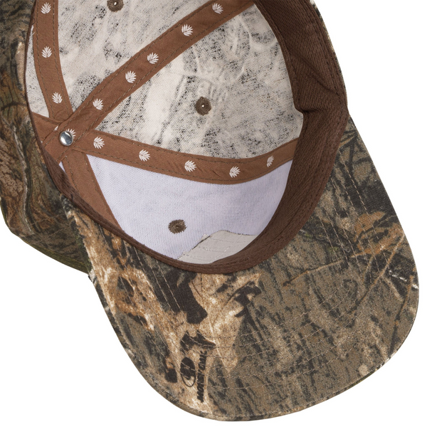 Flat lay of Sendero All Hat No Cattle Hat in Mossy Oak highlighting embroidered patch, Mossy Oak camo pattern, and mesh construction